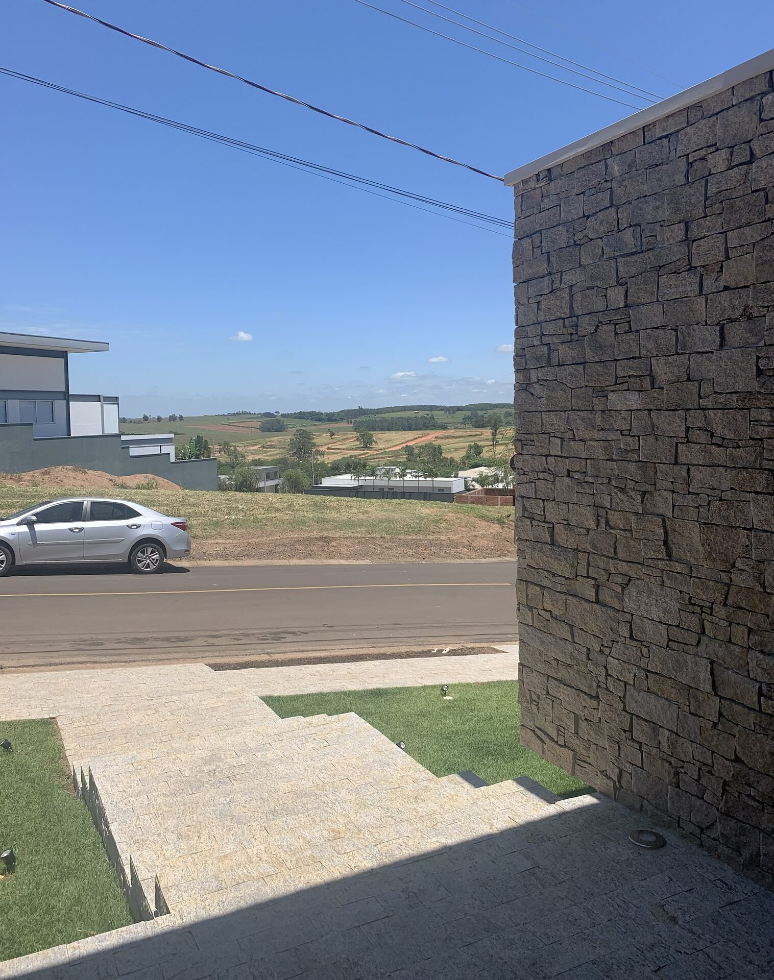 Casa AF — Adamantina: vista da rua com fachada em pedra — arquitetura residencial