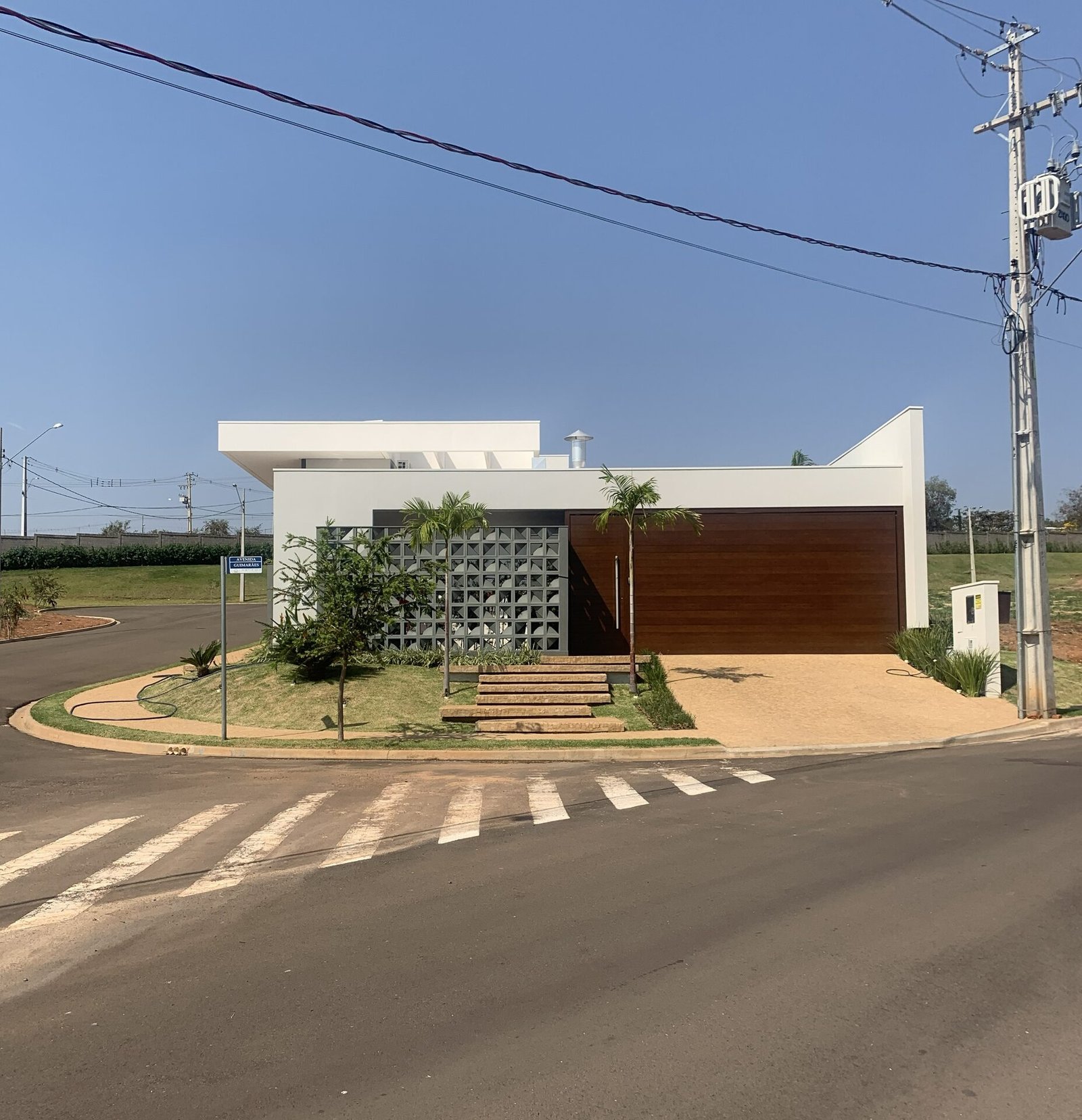 Casa AJ — Adamantina: vista ampla da fachada no cruzamento — projeto de arquitetura residencial