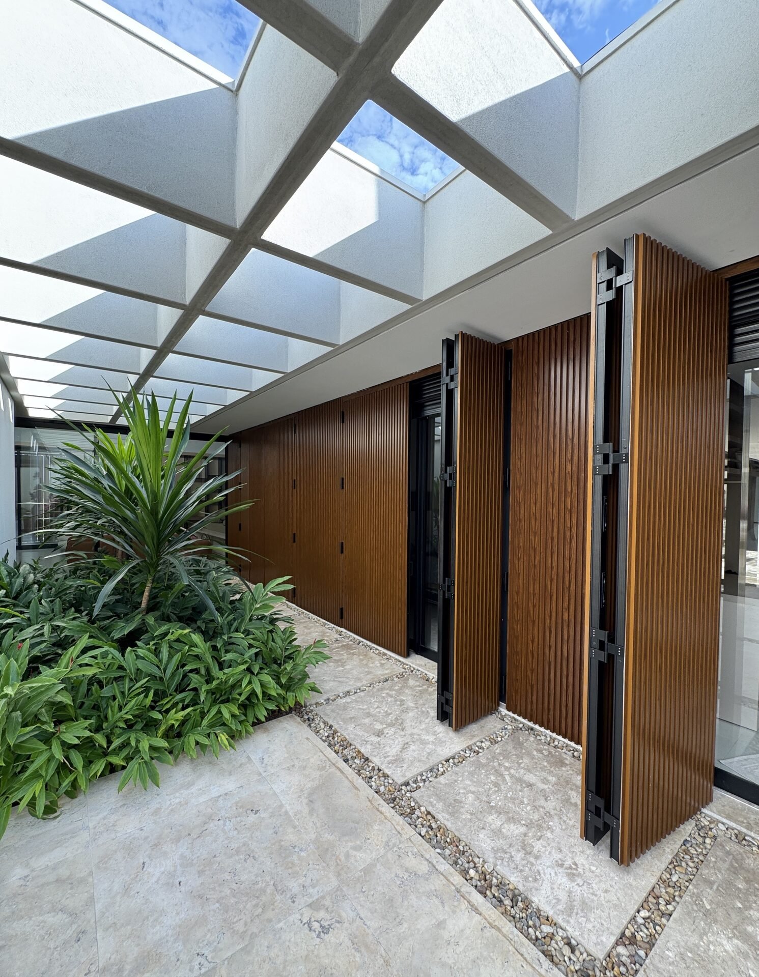 Casa AS — Osvaldo Cruz: pátio interno com painéis de madeira dobráveis — projeto de arquitetura residencial