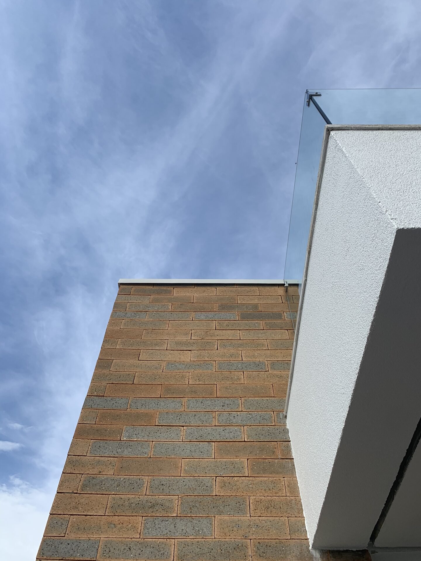 Casa EJ — Adamantina: detalhe do guarda-corpo de vidro sobre o volume cerâmico — projeto de arquitetura residencial