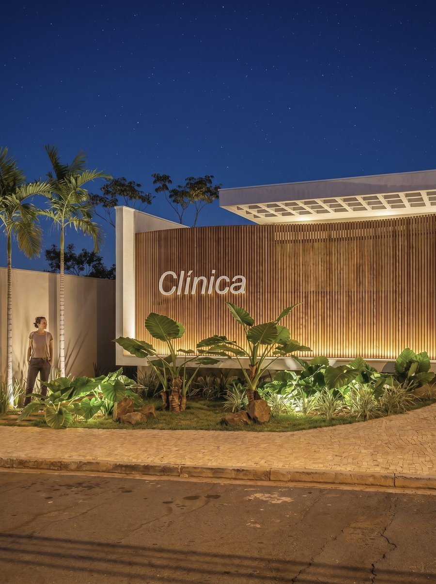 Clínica DW em Adamantina, 2025 — projeto de arquitetura comercial, fachada em brise ripado de madeira iluminada à noite