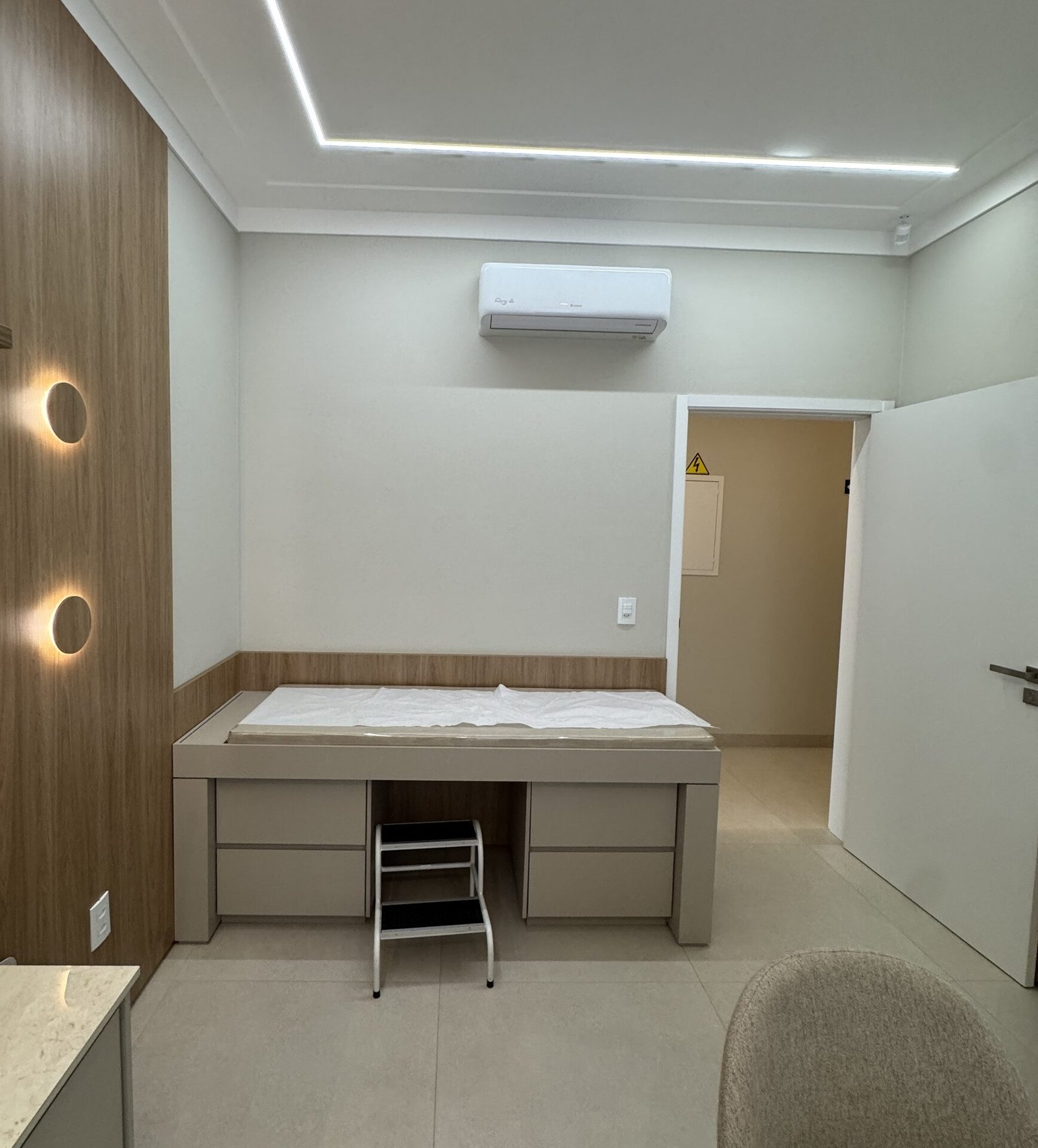 Clínica Integrata — Adamantina: consultório com maca e marcenaria em madeira — projeto de arquitetura comercial