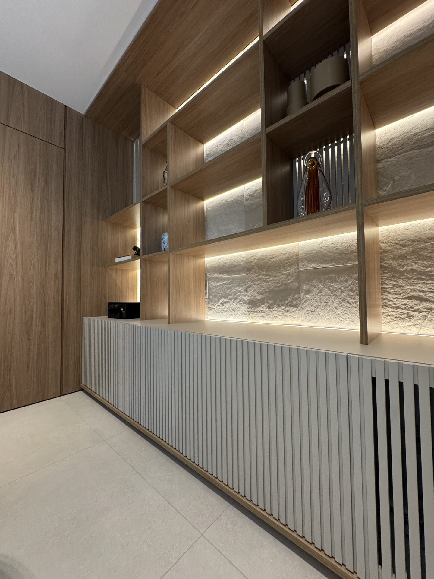 Clínica Integrata — Adamantina: estante com nichos iluminados em pedra — projeto de arquitetura comercial
