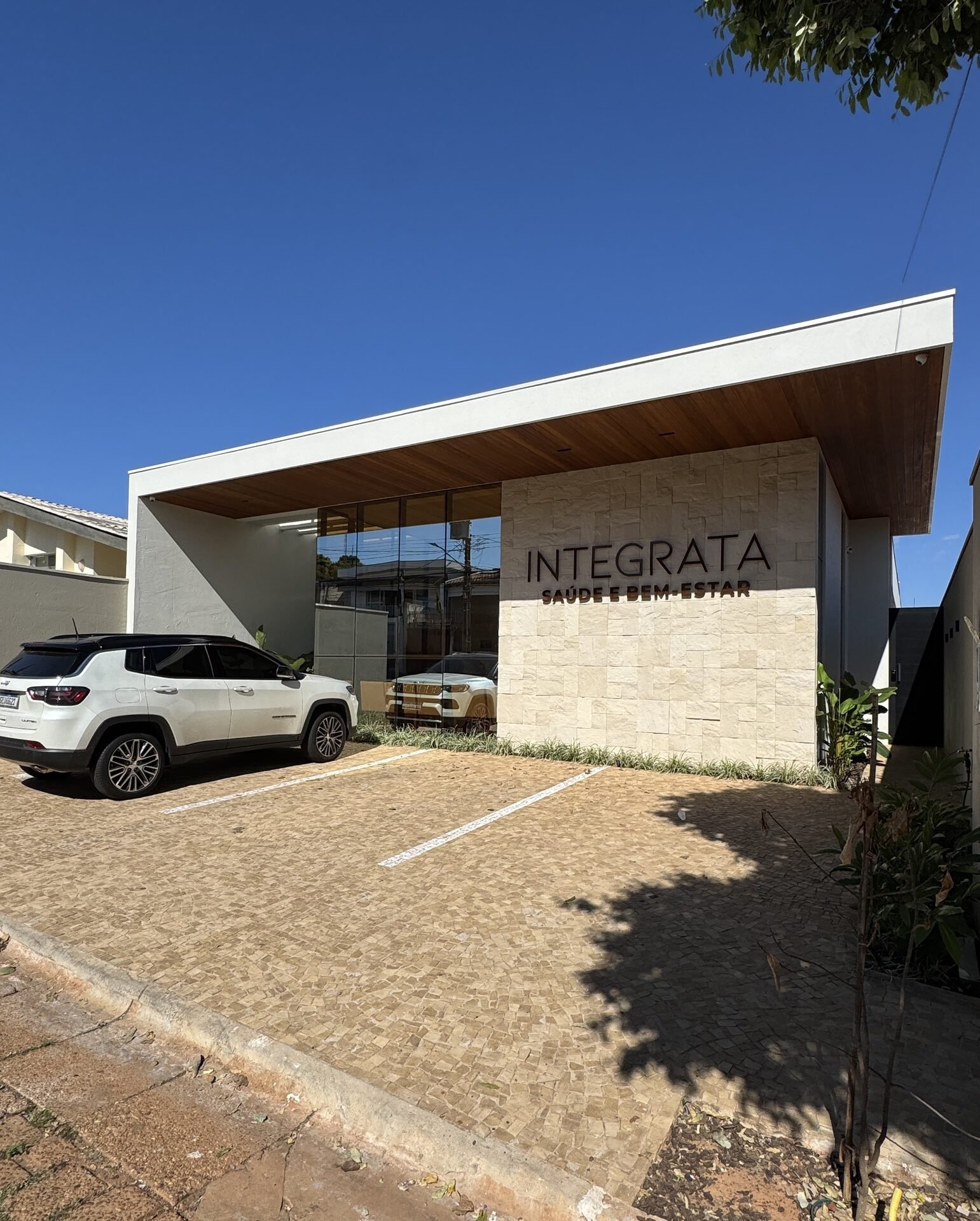 Clínica Integrata — Adamantina: fachada com pedra natural e estacionamento — projeto de arquitetura comercial