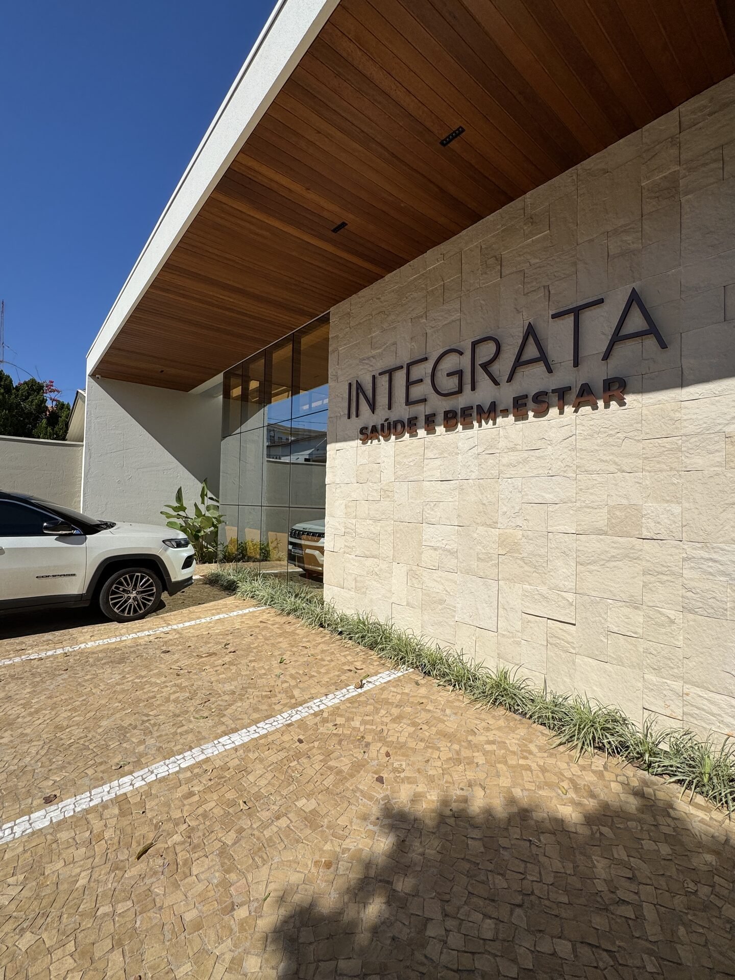Clínica Integrata — Adamantina: detalhe do forro em madeira ripada na entrada — projeto de arquitetura comercial