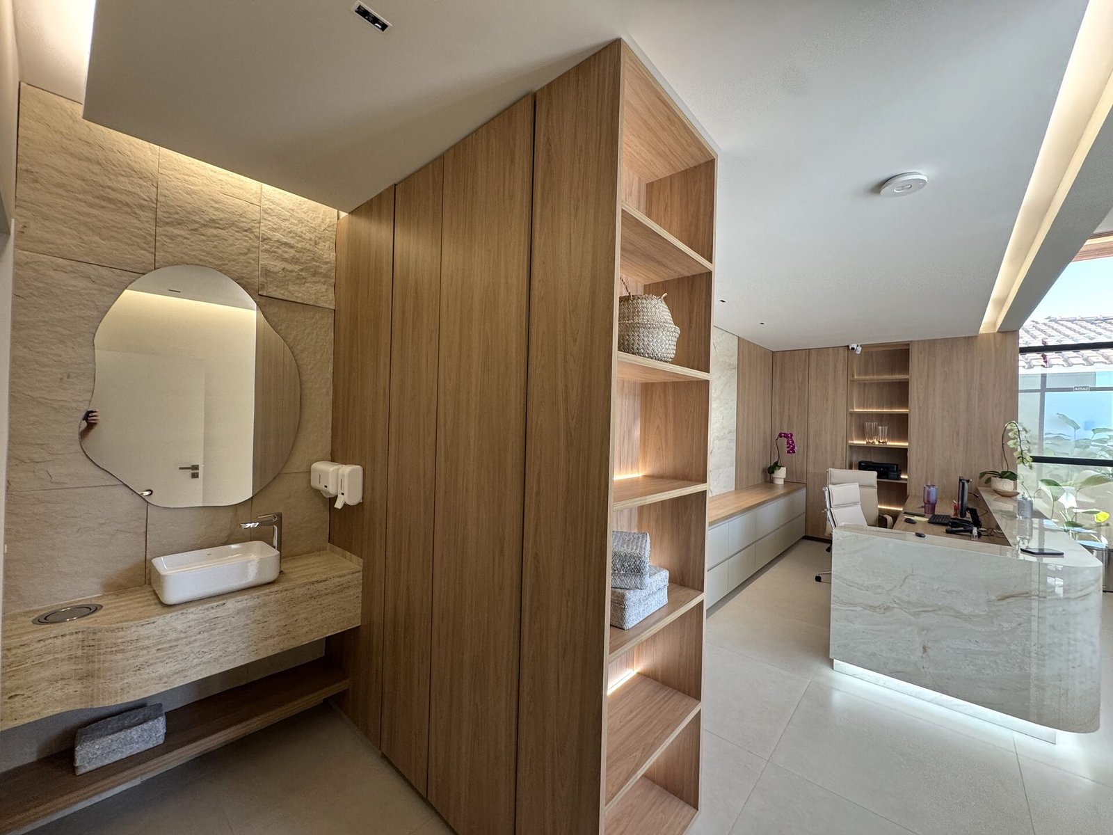 Clínica Integrata — Adamantina: lavabo com bancada em pedra e espelho orgânico — projeto de arquitetura comercial