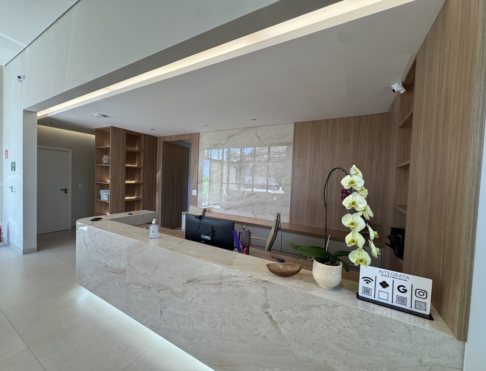 Clínica Integrata — Adamantina: balcão de recepção em mármore — projeto de arquitetura comercial