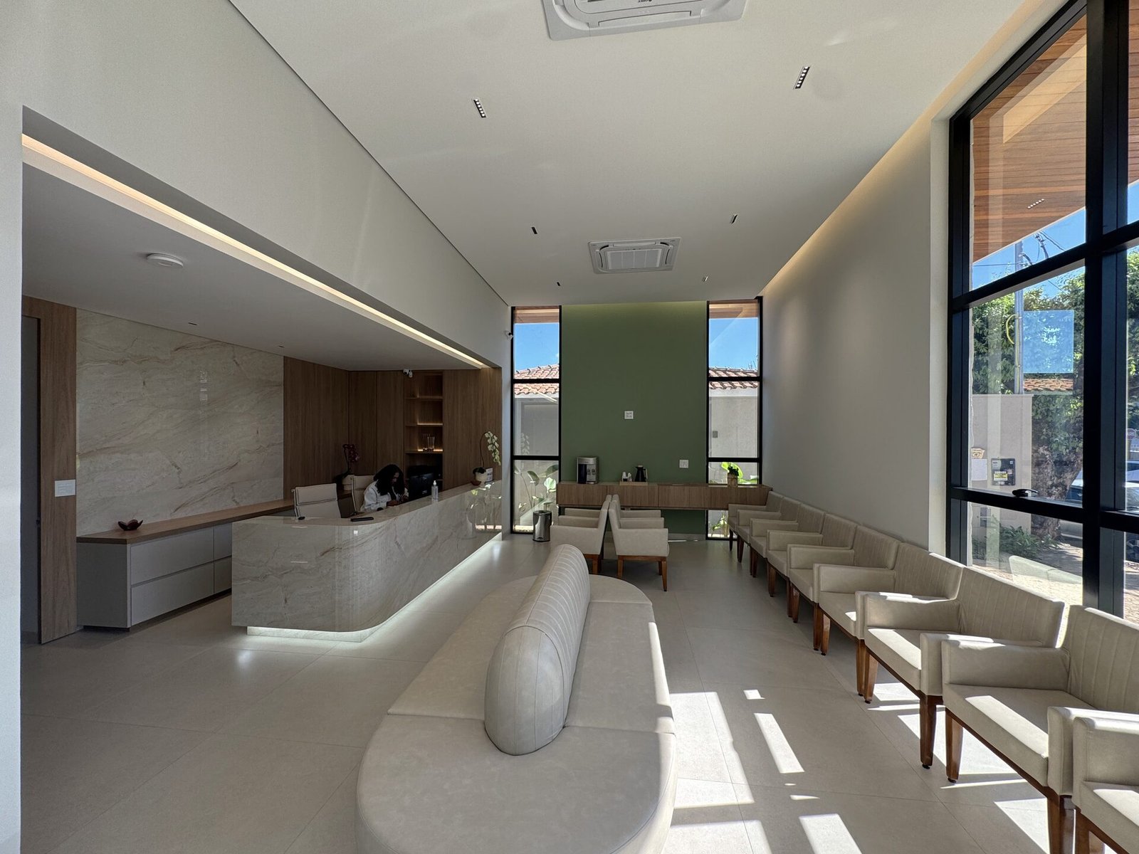 Clínica Integrata — Adamantina: sala de espera com parede verde e poltronas — projeto de arquitetura comercial